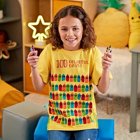 Kid wearing 100 Colorful Days t-shirt featuring 100 sponge-painted Crayola Crayons