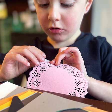 Young boy crafting table decorations. 