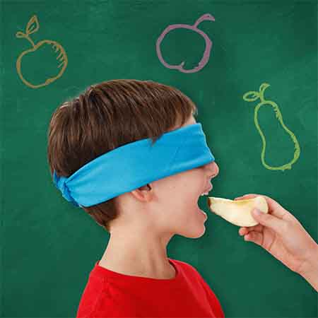 Child playing a blindfolded taste testing game. 
