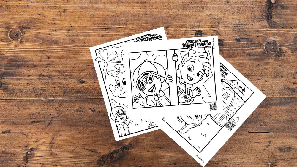 Blippi and friends coloring pages on wooden table.