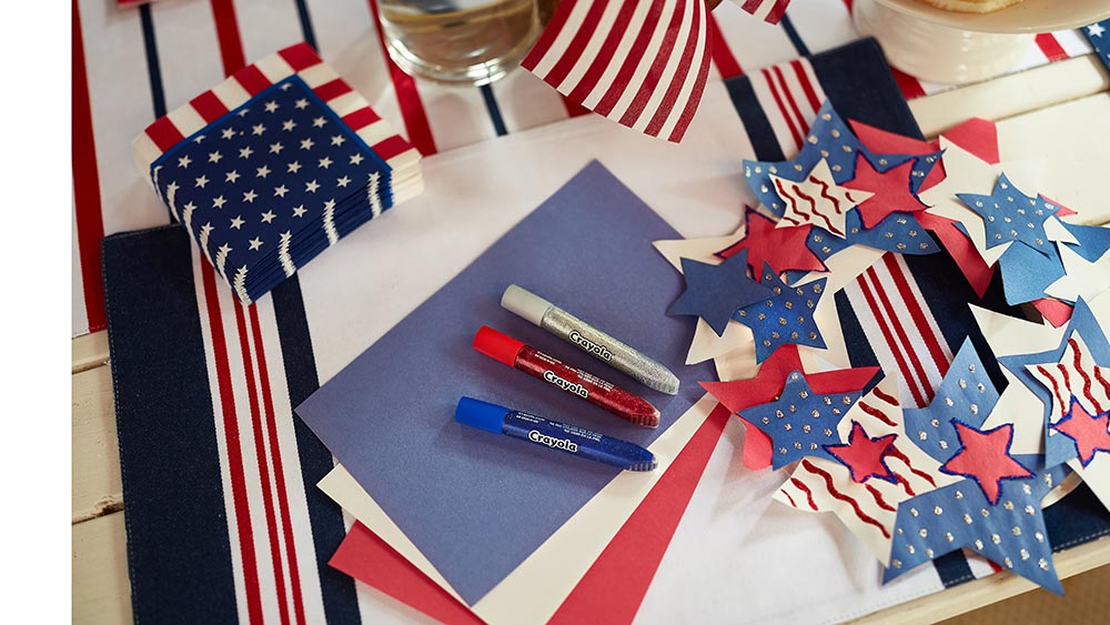 construction paper, glitter glue and 4th of july wreath on tabletop
