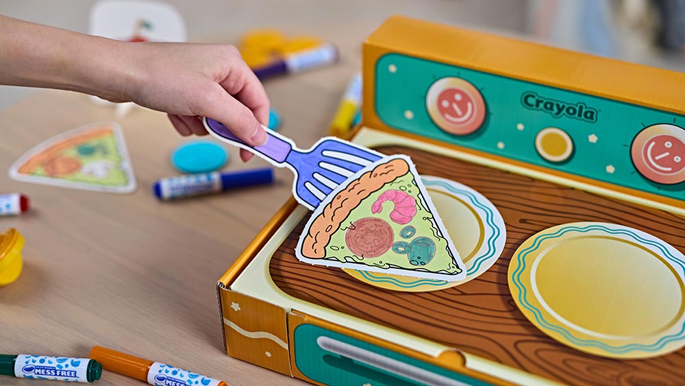 Pretend pizza slice being picked up with a pretend spatula from the color wonder kitchen playset.