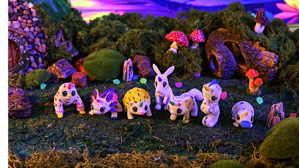 7 scribble scrubbie uni-creatures decorated and displayed in an outdoor setting.