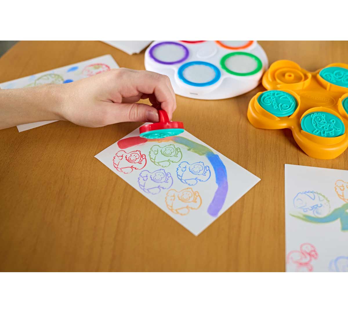 color wonder mess free fingerpainting & stamper kit. child's hand holding stamper about stamped paper. additional contents in the background.