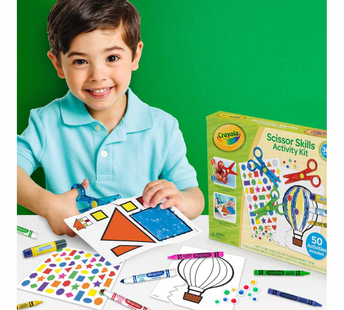 Young Kids Scissor Skills Kit. Young child cutting house template with scissors. Packaging and contents on table.