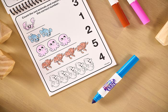 Color & Erase Reusable Activity Pad, Numbers. Activity pad page partially finished surrounded by markers.