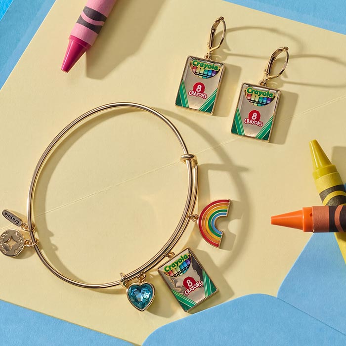 alex and ani box earrings. Multi charm bracelet and box earrings on yellow page with crayons scattered about.
