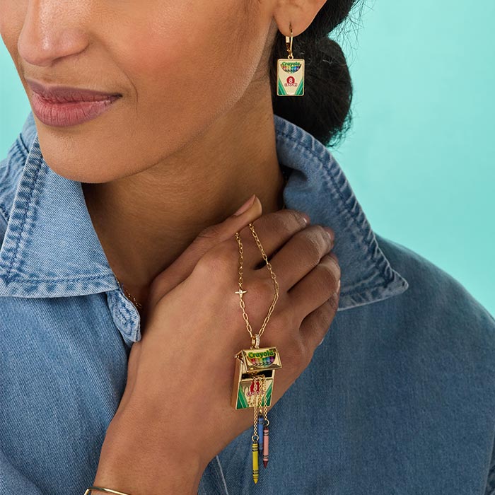 Crayola Teacher Appreciation Crayon Box Locket. Woman holding crayon box locket and wearing box earrings.