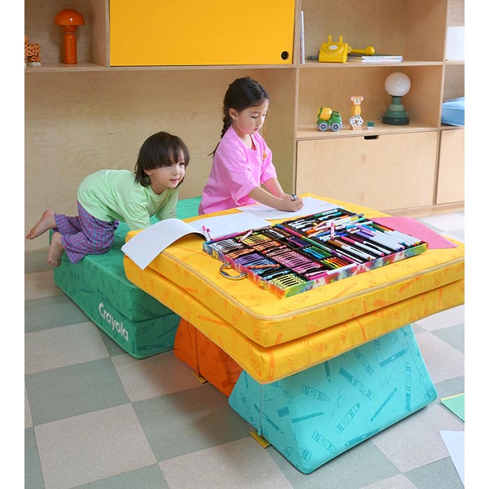 The Crayola Nugget®. Stacked Crayola Nugget pieces to make a table with two children coloring on it.