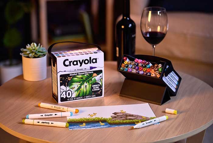 Crayola Alcohol-Based Markers, 40 count set. packaging and contents on table with colored image, succulent and glass of wine.