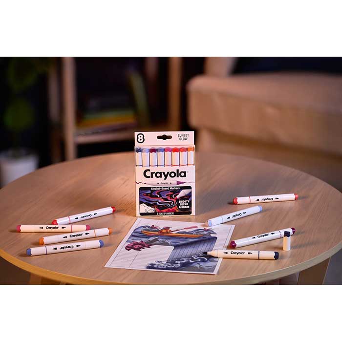 Crayola Color Collections Dual-Tip Alcohol-Based Markers - Sunset (8ct). packaging and contents on table with colored in coloring page.