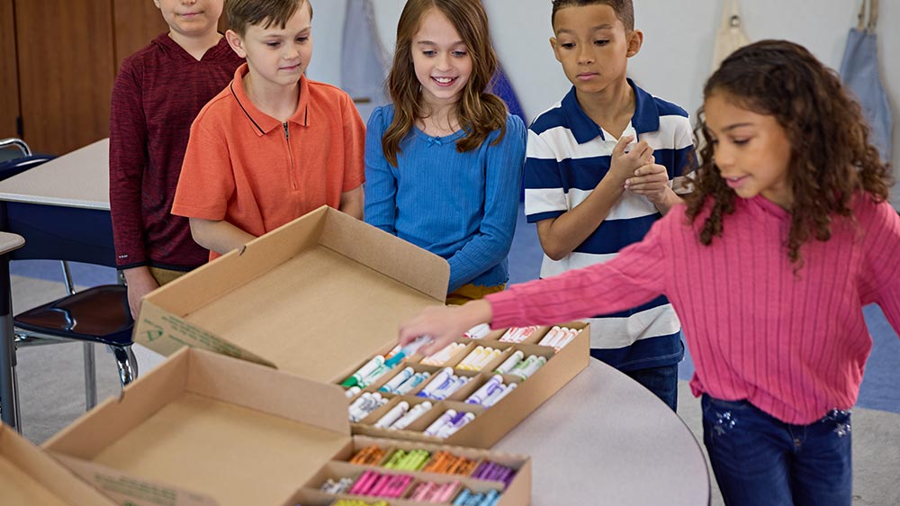 Children picking markers from school bulk boxes.