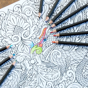 Signature Colored Pencils with partially colored-in Mandala coloring page